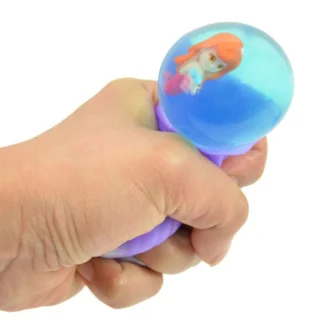 Gniotek sensoryczny w kształcie muszli z wyskakującą syrenką w kolorach fioletowym, różowym, zielonym i niebieskim.